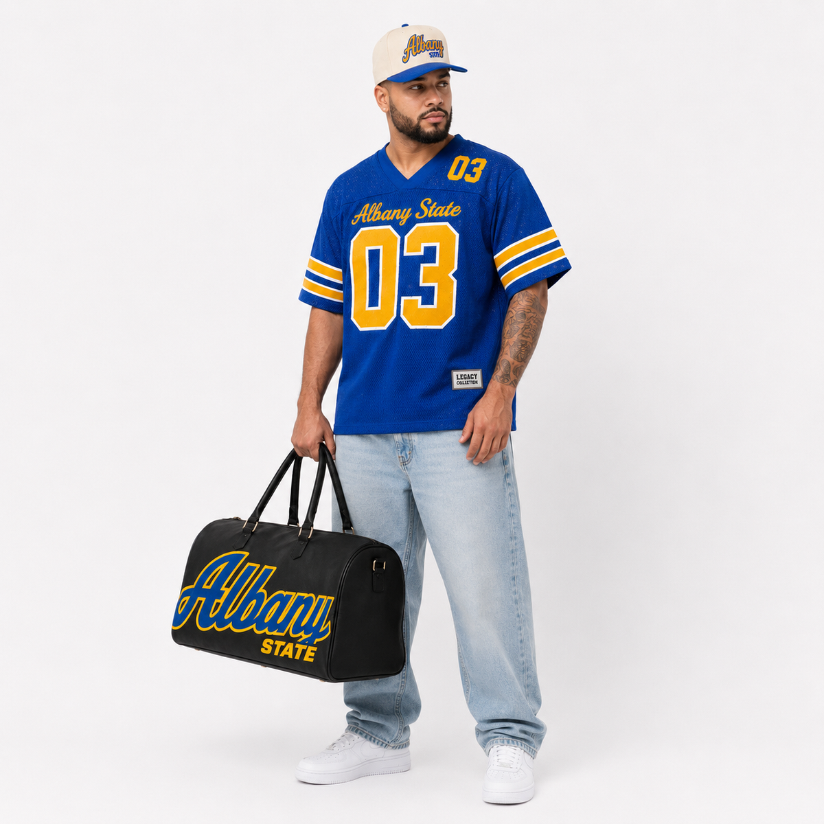 Albany State Legacy Campus Collection male campaign model wearing Albany State jersey and cap with travel bag