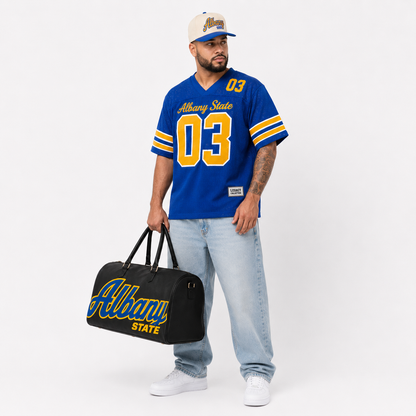 Albany State Legacy Campus Collection male campaign model wearing Albany State jersey and cap with travel bag