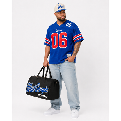 West Georgia Legacy Campus Collection male campaign model wearing West Georgia jersey and cap with travel bag